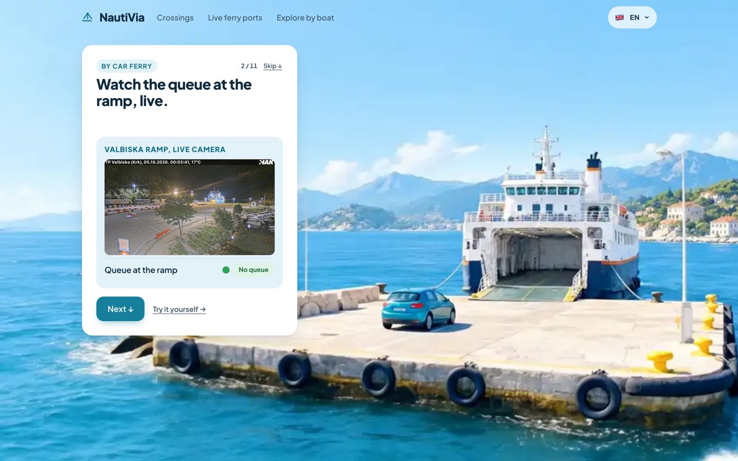 Stop 2 of 11: the car waits at the ferry ramp; the card on the left reads Watch the queue at the ramp, live, and holds the live image from the Valbiska ramp camera